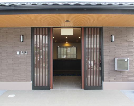 和の雰囲気漂う玄関にはインターホンや郵便ポストがあり、スライド式のドアを左右に開けると中には和の空間が広がっている。