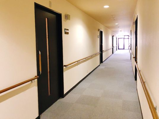 まっすぐな廊下の両サイドに手すりが設置され、フロアはクッションフロア。突き当りには窓もある。
