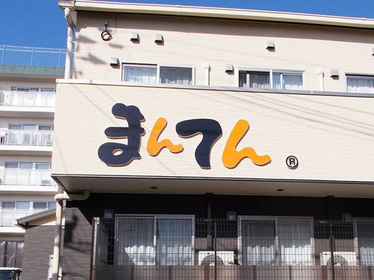 ２階建ての建物はベージュで道路に面して建てられていて、ベランダ部分にホーム名が書かれている。