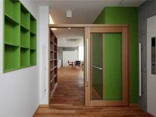 木製の建材を利用して建てられた建物のエントランス付近。色鮮やかな壁が印象的な建物