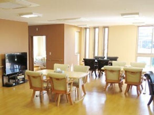 大きなテレビと四人掛けのテーブルと椅子が並べられているリラックススペースの様子