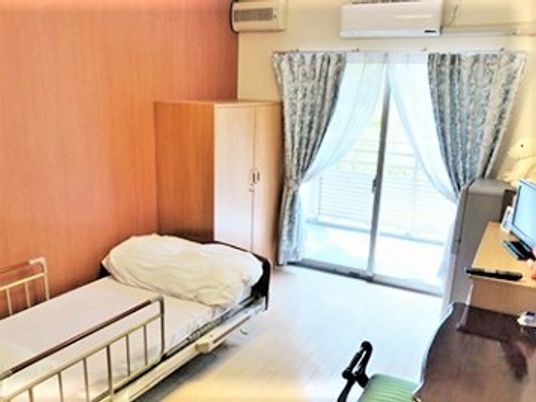 大きな窓が付いた居室。エアコンやベッド、クローゼットなどが付いている。