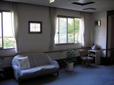 レースのカバーがかけられたソファが置かれた廊下にはいすがセットされた公衆電話もある。