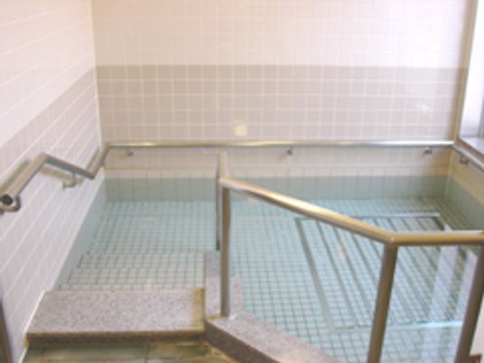 手すり付きのプールのような大浴場の様子。手すりを使って入れる安全性の高い浴槽