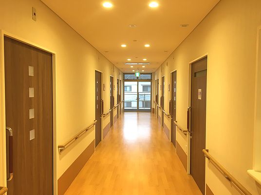 廊下に手すりがついている様子。両側に個室のドアが見えている様子