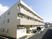 ３階建ての建物が打つている写真。マンションのような建物