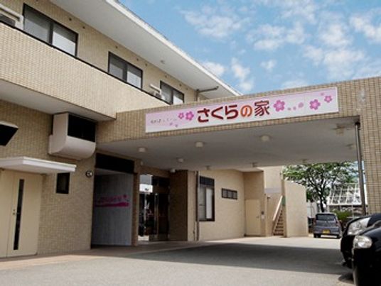 雨除けの用のひさしがついた施設の外観の様子。車止めがあるエントランス