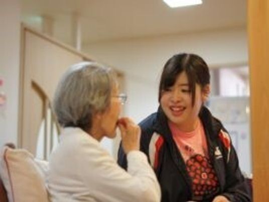 スタッフと高齢者が話している様子。施設内で取られた日常生活の場面