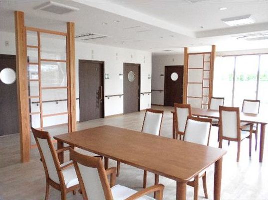 木製の家具が置かれた食堂は和モダンの雰囲気。一般家庭と同じような４人掛けのテーブルが二つ。