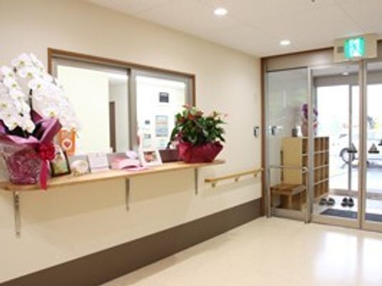 蘭の鉢植えなどが飾られた明るい受け付け。玄関周りにも段差がない。