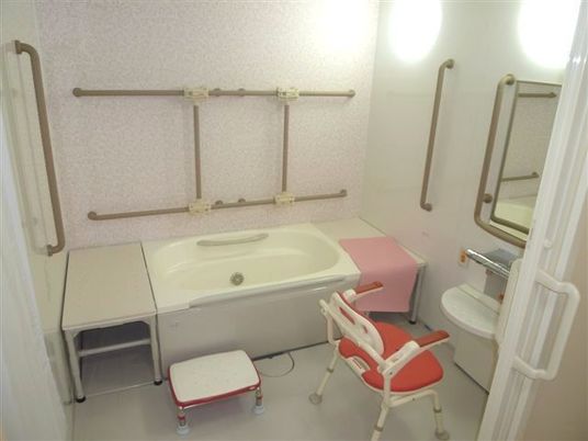 壁にまんべんなく手すりが取り付けられている施設内の浴室の様子