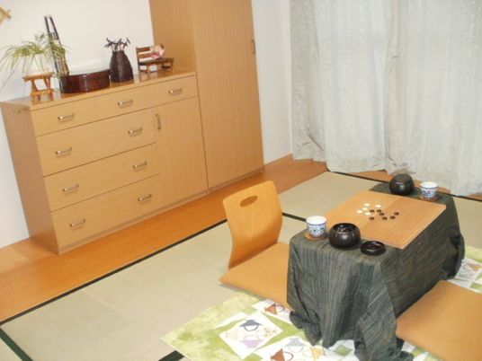 囲碁セットが置かれたテーブルや収納家具が置かれた居室。