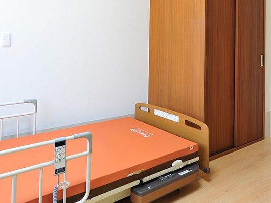 介護用ベッドや収納家具が置かれたフローリングの居室はシンプルな造り。
