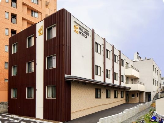 ３階建ての建物の玄関部分には屋根があり、2階と3階にはベランダが付いている。