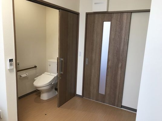 引き戸のトイレには手すりだけでなく、呼び出しボタンもついている。