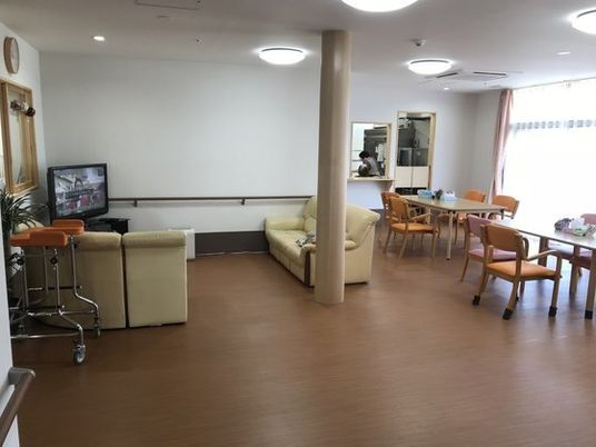 ソファが置かれたテレビコーナーの後ろにはダイニングスペースがあり、奥にはキッチンが見える。