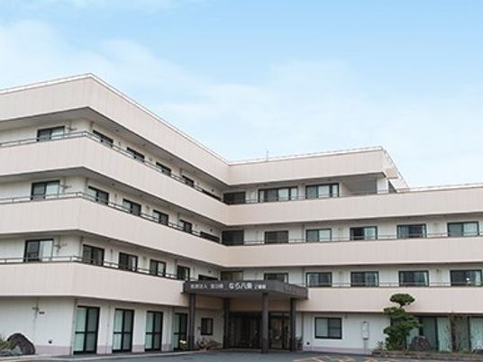 薄曇りの空の下に建つ４階建ての建物