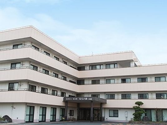 薄曇りの空の下に建つ４階建ての建物