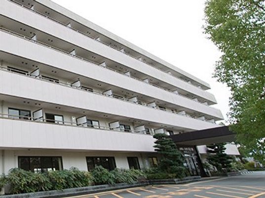 曇りの空の下に建つ５階建ての建物。