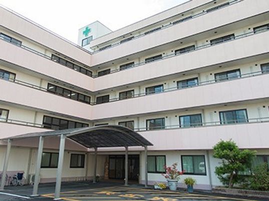 玄関口にアーチ状の屋根を備えた５階建ての建物。