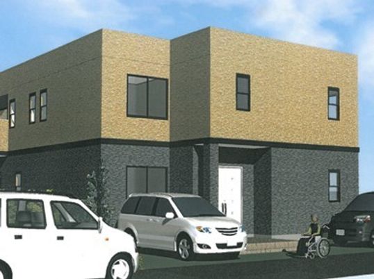 2階建ての建物はツートーンで落ち着いた雰囲気。周辺には駐車スペースがあり、木も植えられている。