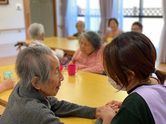 手をつないで見つめ合う利用者とスタッフ