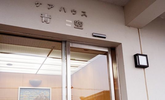 エントランスにはガラスのドアが設置され、ドアの上の外壁にはハウス名が書かれていて、照明も付いている。