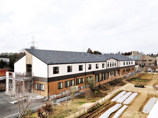 オレンジ色と白色の壁の建物。右側には農園がある