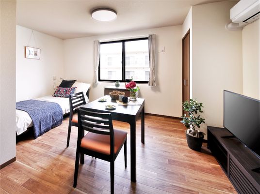 ベッドとテーブル、テレビが置かれた部屋。