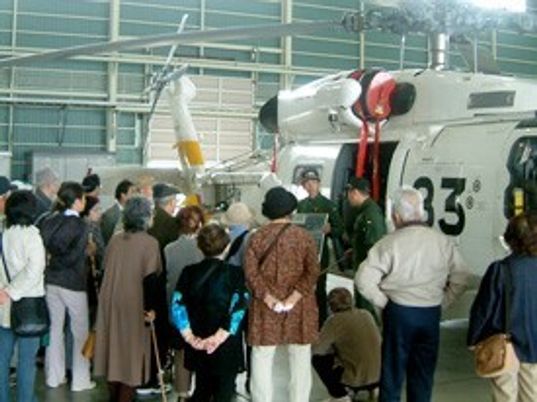 外出イベントで何かを眺めて楽しんでいる高齢者の様子。施設のイベント時の写真