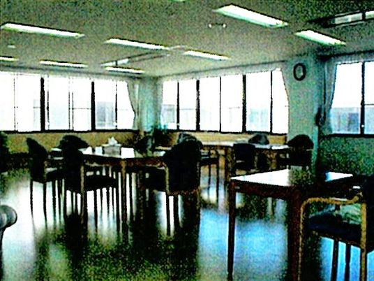 広めのホールに四人掛けのテーブルと椅子が並んでいるリビングの様子