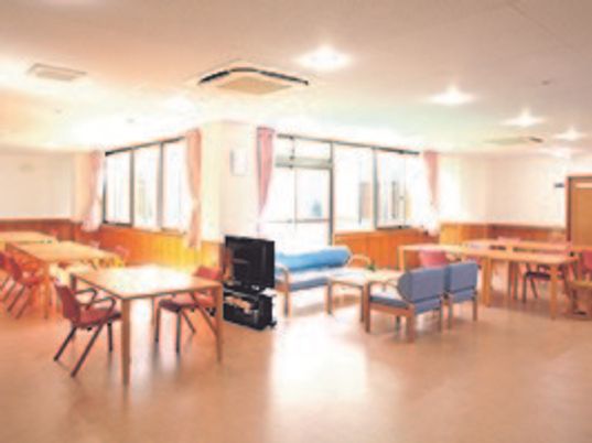 広めのリビングにテーブルと椅子、ソファなどが並んでいる様子。施設内のリラックススペースの写真