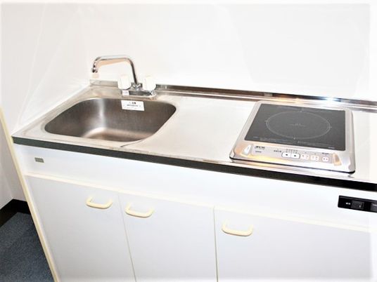 部屋の名k内取り付けてある小さなキッチンスペース。電磁調理器が置いてあるタイプ