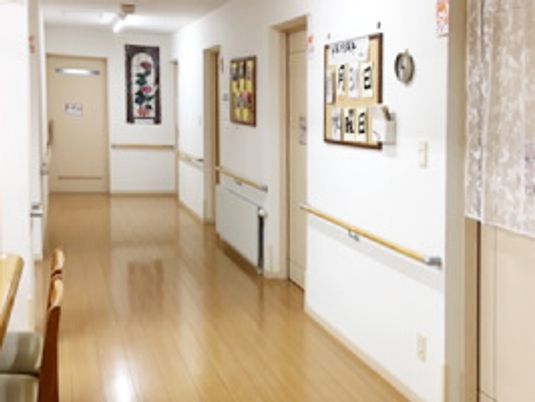 廊下の右側には居室が並び、写真や創作作品が飾られている。