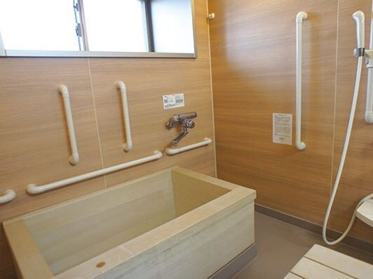 木製の浴槽が設置された浴室には手すりが付き、シャワースペースもある。