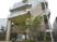 白を基調とした4階建ての建物の前には館銘板が設置されていて、草木が植えられている。