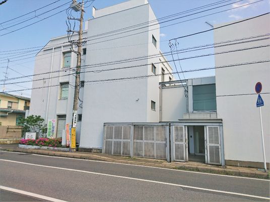白い建物が二つ並んで建てられ、真ん中にある渡り廊下でつながっている。