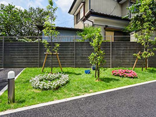 色鮮やかな緑に囲まれている中庭の様子。植樹された機と花が整然と並んでいる