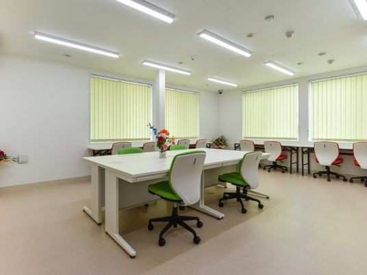 スタッフが話し合える広めの共有スペースの様子。事務机と椅子が並んでいる部屋