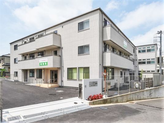 ハートケアライフ福寿園の正面玄関を写した写真。鉄骨造３階建ての建物