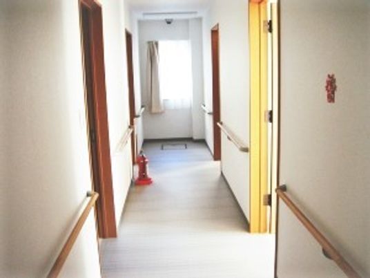手すりがついている施設内の廊下の様子。両側に個室のドアがある様子がわかる