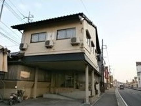 ２階建ての建物は和風の外観。１階部分には駐車スペースもある。