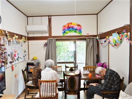 明るく家庭的な雰囲気の食堂の中央に大きなテーブルが置かれ、入居者が数名自由に過ごしている。