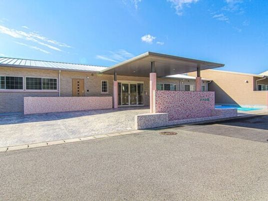 平屋建ての建物は日当たりがいい場所にあり、大きな車寄せが玄関に付き、明るい雰囲気。