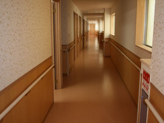 まっすぐな廊下の両サイドに手すりが設置され、幅が広く、壁紙は花柄。