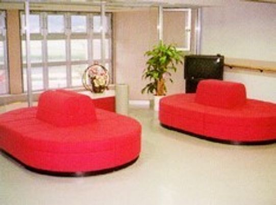 赤いソファ型の椅子がセットされたロビーにはテレビもある。