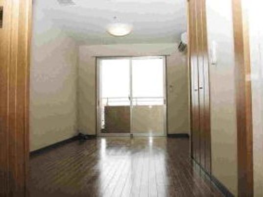 一人用の小さな部屋の写真。右側に収納、中央に窓がある施設内の居室スペース