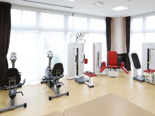 高齢者用のトレーニングマシンが並べられている施設内の一室。明るい二面採光の部屋