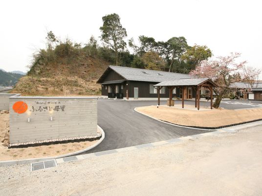 黒を基調とした平屋建ての建物。ホームの後ろには山があり、自然に囲まれた環境。