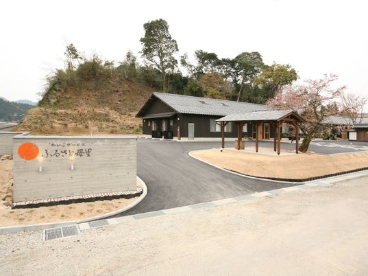 黒を基調とした平屋建ての建物。ホームの後ろには山があり、自然に囲まれた環境。